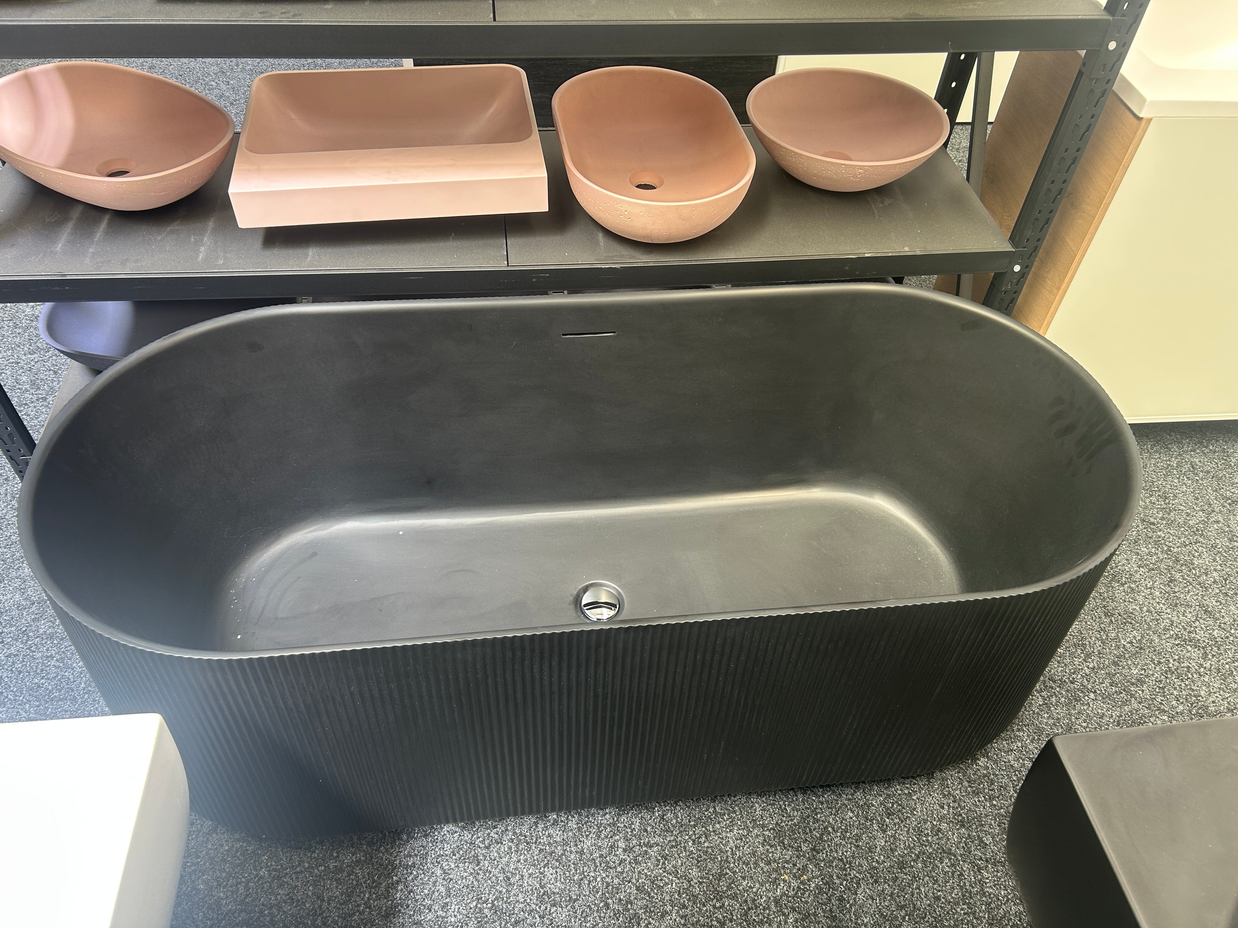 A large matte black freestanding bathtub or soaking tub with a ribbed exterior and smooth interior clearance sale