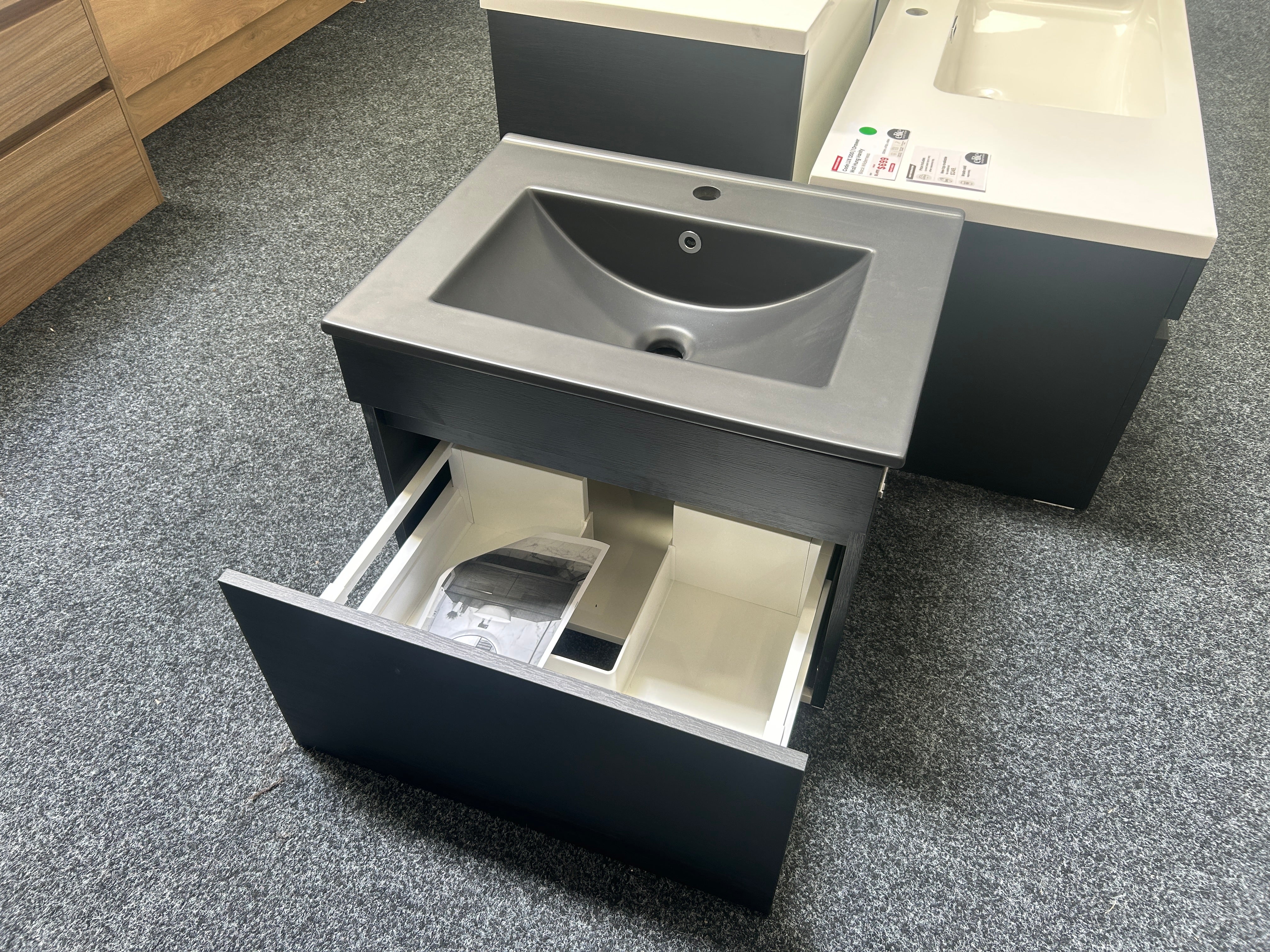 A modern gray bathroom vanity with an integrated sink and an open drawer showing storage compartments,clearance sale deal 